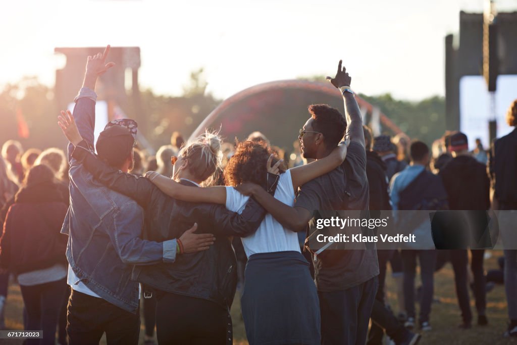 Friends with arms in the air at festival concert