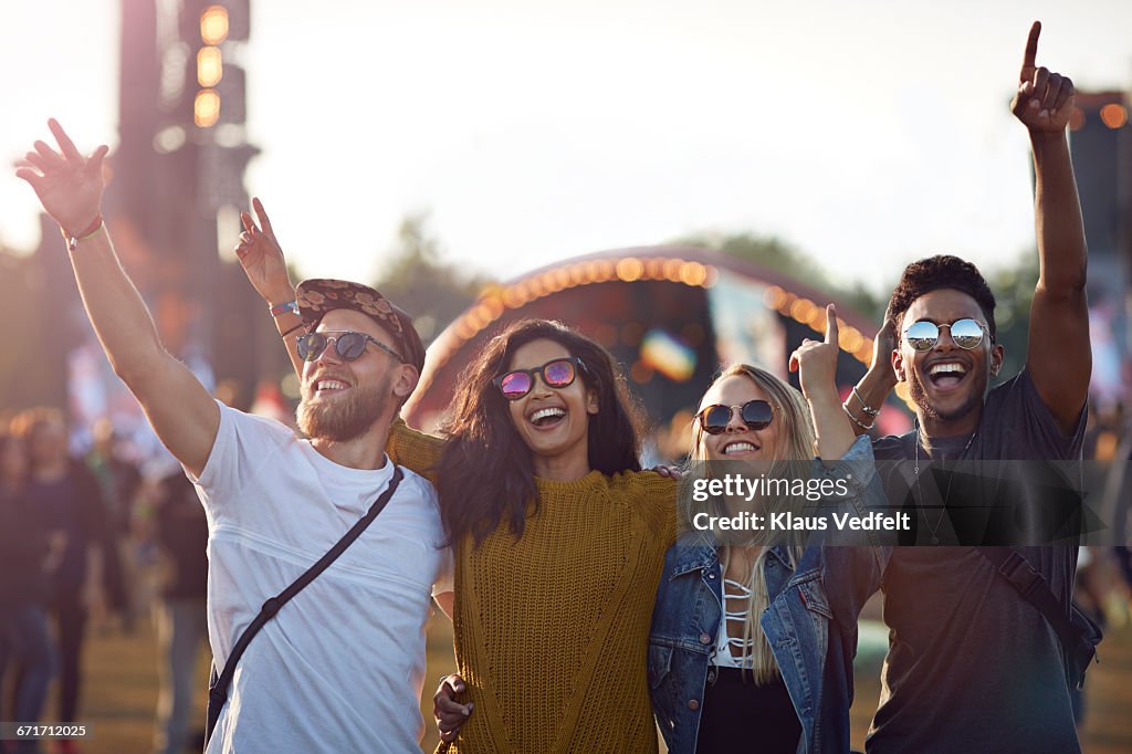 Friends with arms in the air at festival concert
