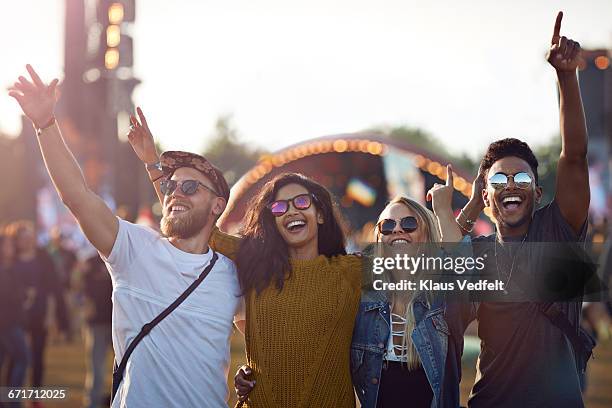 friends with arms in the air at festival concert - holiday event 個照片及圖片檔