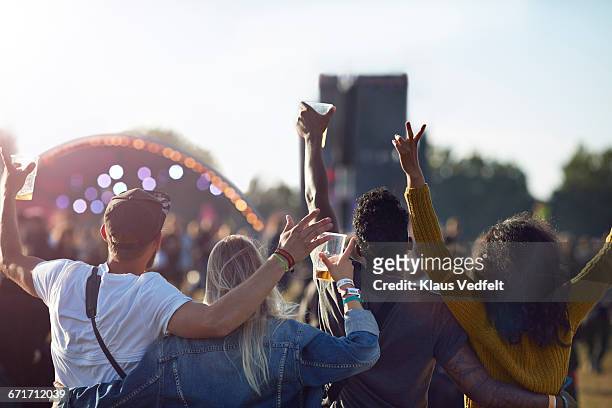 friends having arms in the air in front of stage - music festival stock pictures, royalty-free photos & images