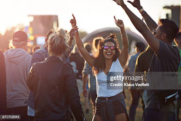 friends with arms in the air at festival concert - festival of colour stock-fotos und bilder