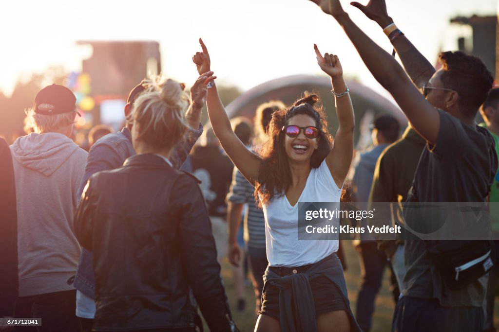 Friends with arms in the air at festival concert