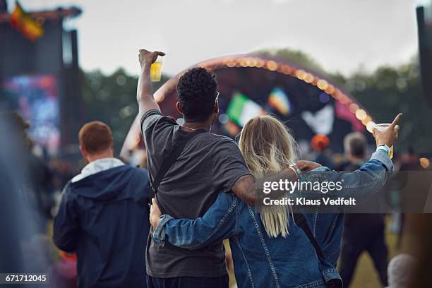 couple watching concert & holding beers, rear view - couple concert stock pictures, royalty-free photos & images