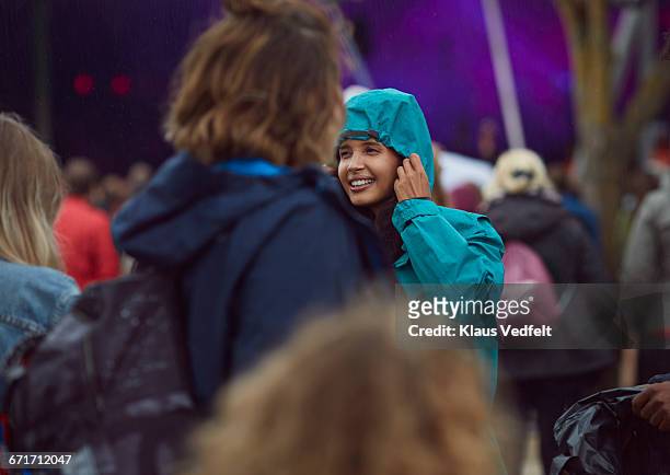 woman putting on hood in the rain at festival - music festival 2016 weekend 2 stock pictures, royalty-free photos & images