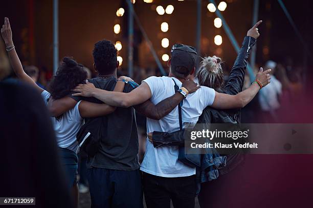 friends with arms around each other at concert - music festival day 4 stockfoto's en -beelden