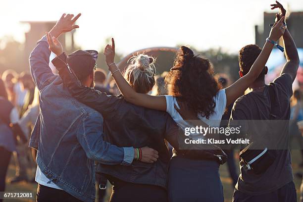 friends with arms in the air at festival concert - entertainment evenement stockfoto's en -beelden