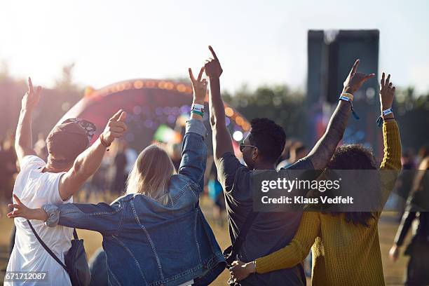 friends having arms in the air in front of stage - outdoor music festival stockfoto's en -beelden