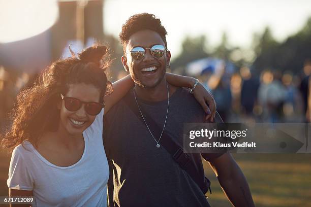 couple laughing together at big festival - couple concert photos et images de collection