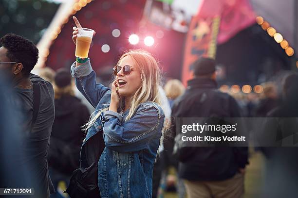 woman cheering with beer at concert - scène de vie photos et images de collection