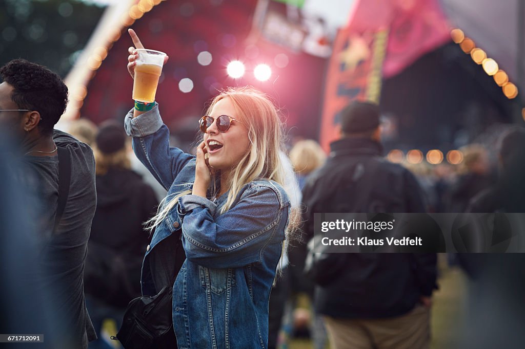 Woman cheering with beer at concert