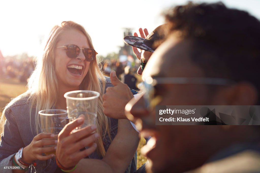 Friends laughing at big festival with beers