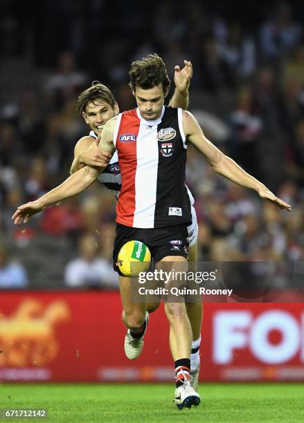 Dylan Roberton of the Saints kicks whilst being tackled by Tom Hawkins of the Cats during the round five AFL match between the St Kilda Saints and...