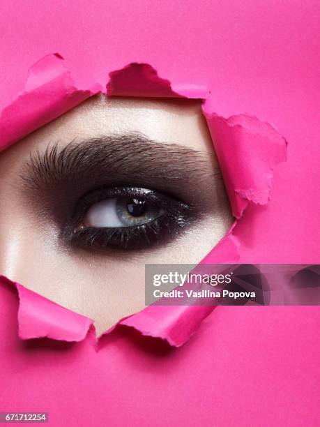 female eye looking through paper - black eyeshadow stock pictures, royalty-free photos & images