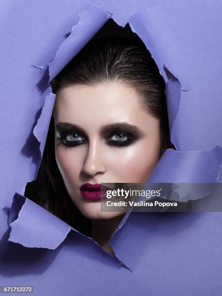 beautiful woman looking through paper - black eyeshadow stock pictures, royalty-free photos & images