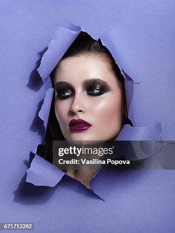 Beautiful Woman Looking Through Paper Foto de stock - Getty Images