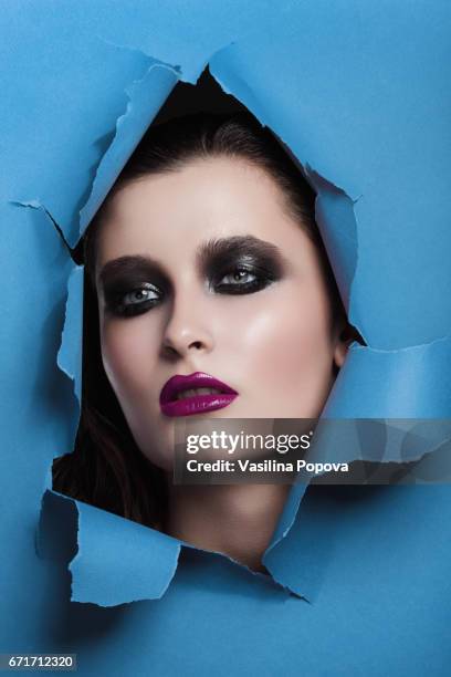 beautiful woman looking through paper - black eyeshadow stock pictures, royalty-free photos & images