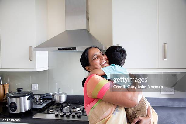 happy grandmother hugging young grandson at home - asian grandmother stock pictures, royalty-free photos & images