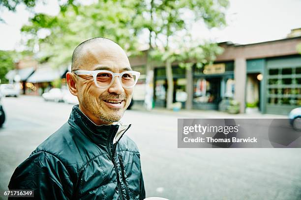 smiling man running errands in neighborhood - men in their 50s stock pictures, royalty-free photos & images