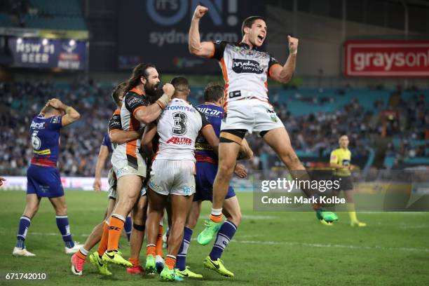 Aaron Woods, Michael Chee-Kam and Mitch Moses of the Tigers celebrates victory with his team during the round eight NRL match between the Wests...