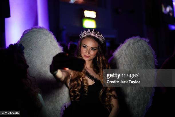 Performer wearing angel's wings takes a selfie at the grand final of Miss USSR UK at the Troxy on April 22, 2017 in London, England. The annual...