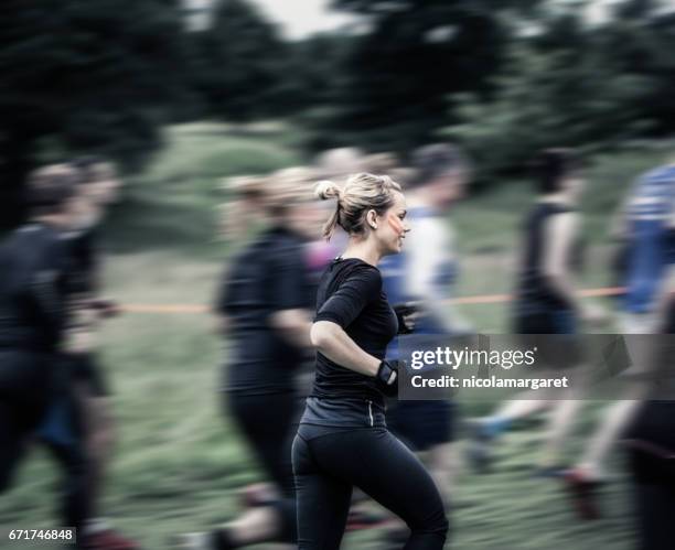 young woman running in race - nicolamargaret stock pictures, royalty-free photos & images