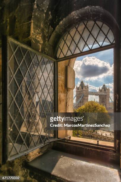 portrait of tower bridge from an old window at tower of london - tower of london stock pictures, royalty-free photos & images