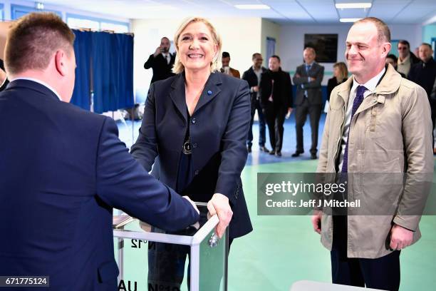 National Front Leader Marine Le Pen, casts her vote for the French elections into the ballot box at a polling station on April 23, 2017 in Henin...