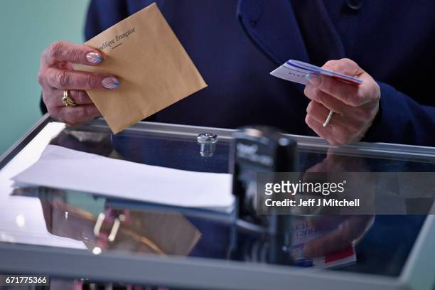 Members of the public cast their vote for the French elections in a polling station on April 23, 2017 in Henin Beaumont, France. French people go to...