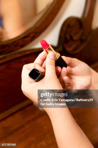 young woman holding lipstick - woman lipstick rearview stock-fotos und bilder