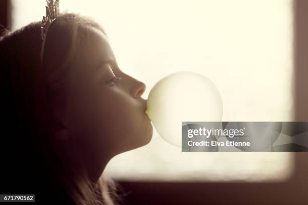 back lit child blowing bubbles next to a window - bubble gum kid stock pictures, royalty-free photos & images