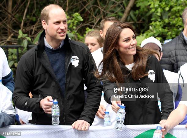 Prince William, Duke of Cambridge and Catherine, Duchess of Cambridge hand out water to runners during the 2017 Virgin Money London Marathon on April...