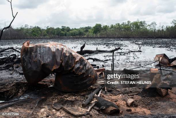 Picture taken on April 19, 2017 shows a destroyed cooking tank at an illegal oil refinery site, in the Niger Delta region, near the city of Warri....