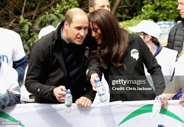 Prince William, Duke of Cambridge and Catherine, Duchess of Cambridge hand out water to runners during the 2017 Virgin Money London Marathon on April...