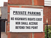 a sign outside near a private residential old people car park saying private parking no highways rights exist no shall accrue beyond this point white and black on brick warning restriction english uk road law