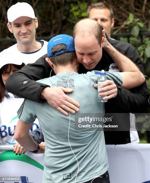 Prince William, Duke of Cambridge hugs a runner as he hands out water during the 2017 Virgin Money London Marathon on April 23, 2017 in London,...