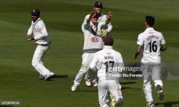 Surrey bowler Jade Dernbach celebrates with team mates after dismissing Warwickshire batsman Jonathan Trott caught by Kumar Sangakkara during day...