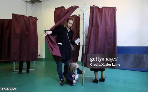 Parisian woman walks out of a voting booth with her child in the 15th district as France goes to the polls to vote in the first round of Presidential...