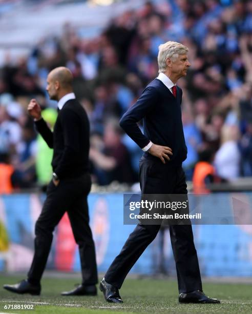 Arsene Wenger manager of Arsenal reacts while Josep Guardiola manager of Manchester City celebrates as Sergio Aguero of Manchester City scores the...