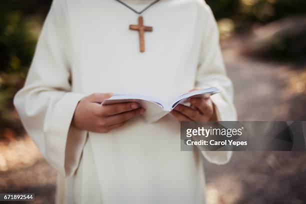 medium section portrait boy reading bible in his first communion - religious confirmation fotografías e imágenes de stock