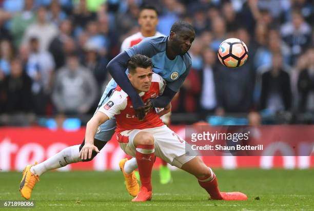 Granit Xhaka of Arsenal and Yaya Toure of Manchester City compete for the ball during the Emirates FA Cup Semi-Final match between Arsenal and...
