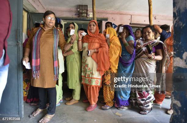 People stand in a queue at a polling station to cast their votes at Rajouri Garden, on April 23, 2017 in New Delhi, India. Voting for 270 seats...