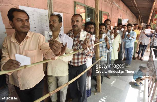 People stand in queue to cast their votes for the MCD election 2017, in East Delhi polling station, on April 23, 2017 in New Delhi, India. Voting for...