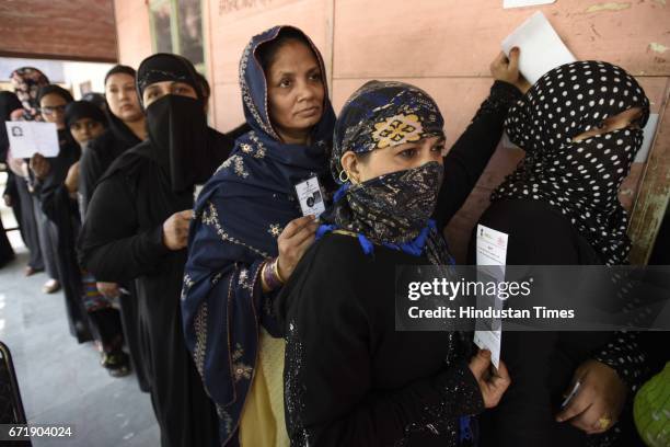 People stand in queue to cast their votes for the MCD election 2017, in East Delhi polling station, on April 23, 2017 in New Delhi, India. Voting for...