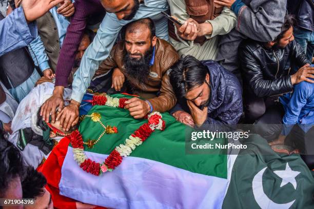 Kashmiri Muslims touch the body of Younis Maqbool Ganie, a pro Kashmir rebel killed in a gun battle with Indian government forces, during his funeral...
