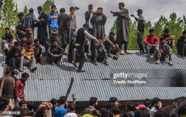 Kashmiri Muslim look from the roof top of a building towards the body being carried of Younis Maqbool Ganie, a pro Kashmir rebel killed in a gun...