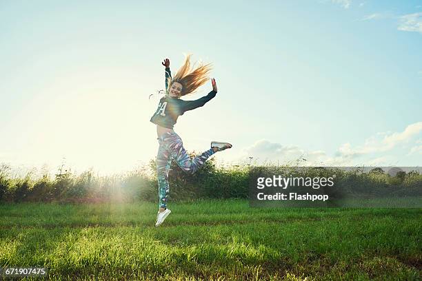 portrait of woman having fun at a music festival - frau springt hüpft stock-fotos und bilder