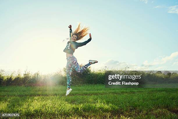 portrait of woman having fun at a music festival - jumping for joy stock pictures, royalty-free photos & images