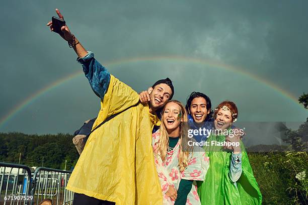 group of friends having fun at a music festival - レインコート ストックフォトと画像