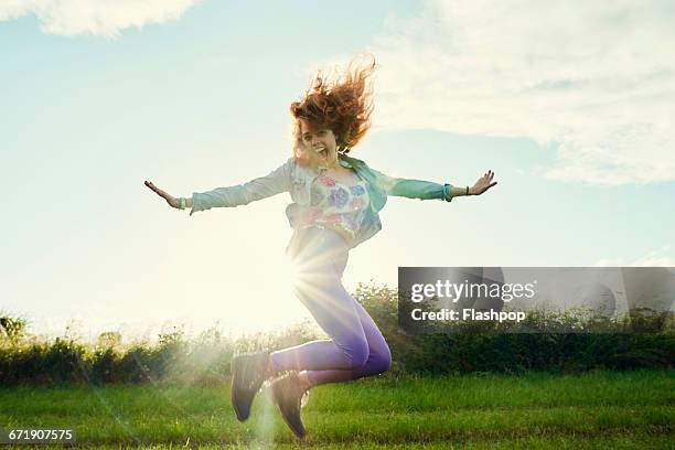 portrait of woman having fun at a music festival - jump for joy stock pictures, royalty-free photos & images