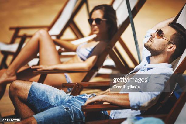 tomar el sol. - man on the beach relaxing in deckchair fotografías e imágenes de stock